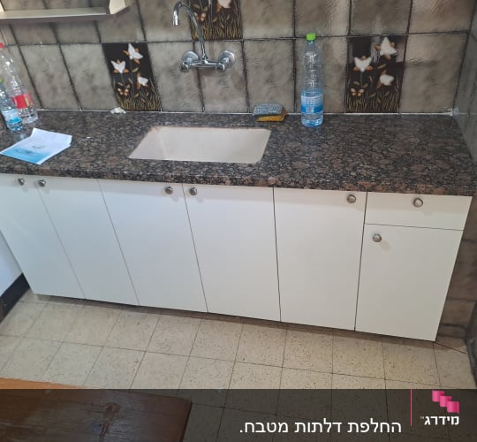 מטבח עם ארונות כיור וברז